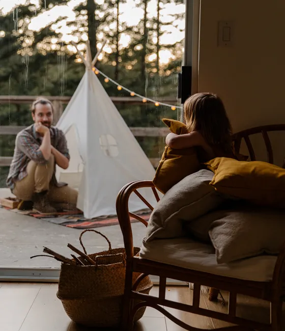 little-kid-in-armchair-looking-at-father-sitting-near-wigwam-3932958